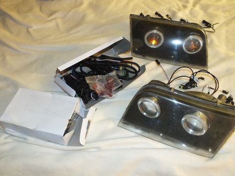 2003 Ford Crown Victoria - Custom headlamps with twin projectors next to a box of HID wiring and mounting hardware.