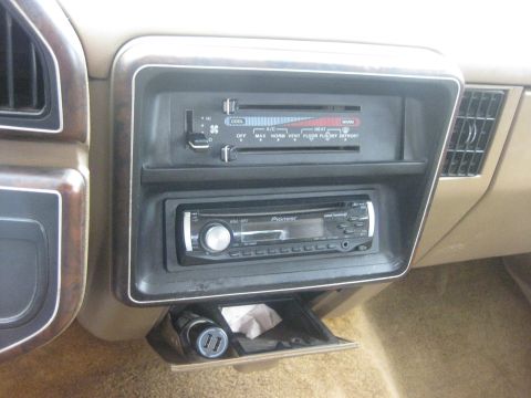 1994 Ford Bronco - The interior of an older vehicle shows the climate controls, an aftermarket stereo, and a modern USB charging port.