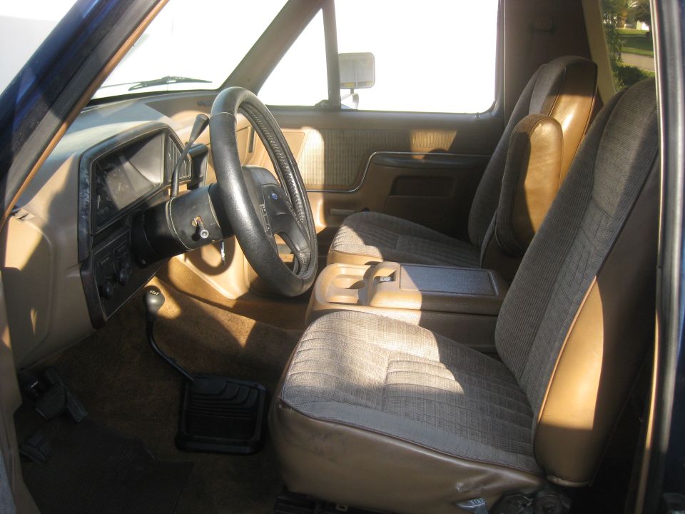 Interior shot of a Ford Bronco, showing the driver's seat, passenger seat, dashboard, and steering wheel