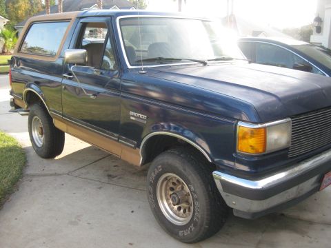 1994 Ford Bronco - This blue Ford Bronco with tan trim is shown from the front quarter angle.