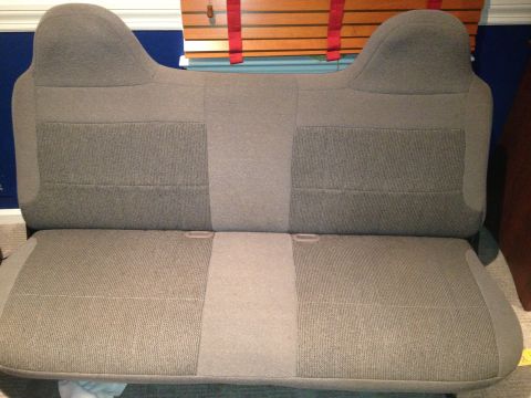 1996 Ford F-150 - A gray fabric bench seat, likely from a truck, is shown indoors.