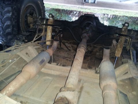 1986 Ford Bronco - Undercarriage of a vehicle, focusing on the exhaust system and drivetrain components.