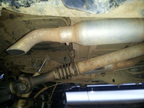 1986 Ford Bronco - A view of the vehicle's undercarriage, focusing on the exhaust system and driveshaft components.