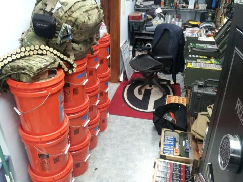 1986 Ford Bronco - A collection of orange buckets is stacked high, topped with camouflage gear and a bandolier of ammunition.