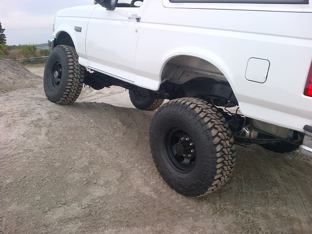 White Ford Bronco, lifted, with large off-road tires, side view
