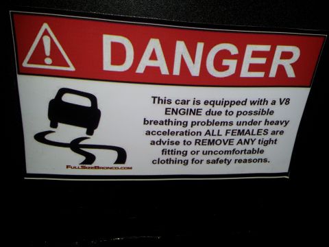 1986 Ford Bronco - A "Danger" sticker warns about a V8 engine and advises females to remove tight clothing for safety.