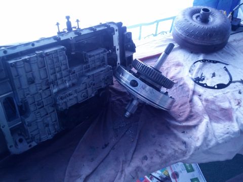 1995 Ford Bronco - Transmission components laid out for inspection, including the case, gears, and torque converter.