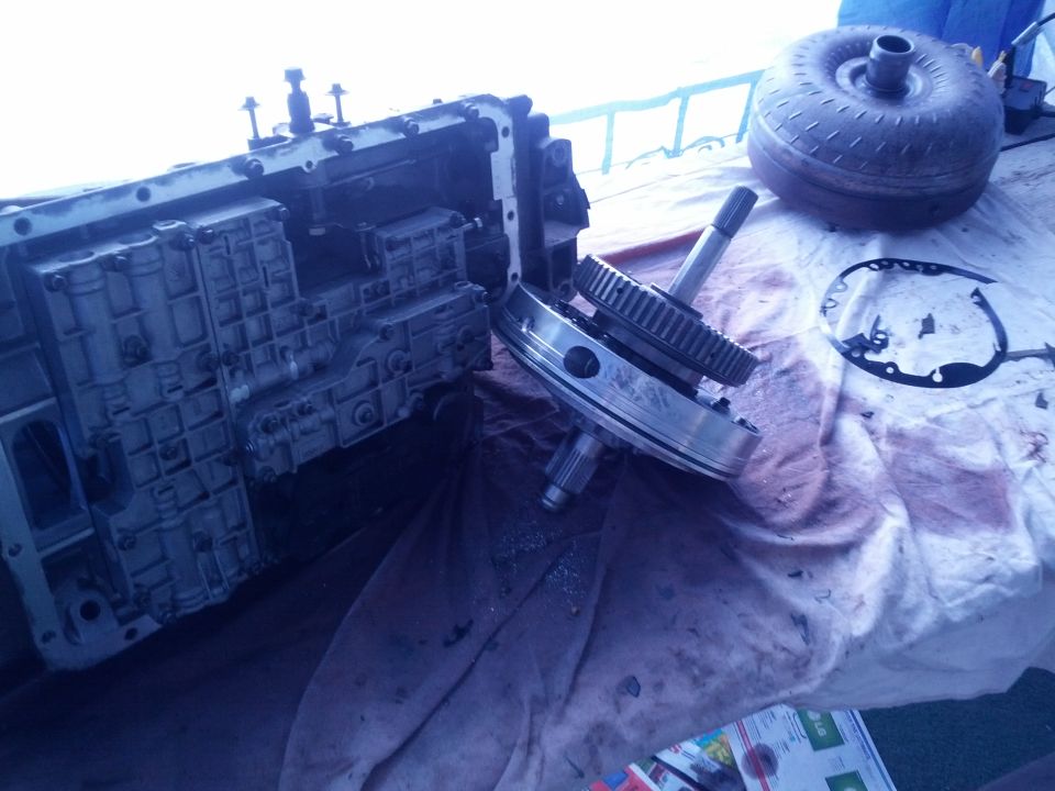 Disassembled transmission case with gears and torque converter on a cloth