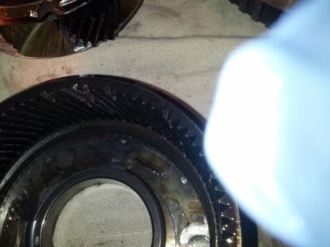 1995 Ford Bronco - Damaged transmission gears are shown in a close-up view, with a blue glove obscuring part of the frame.