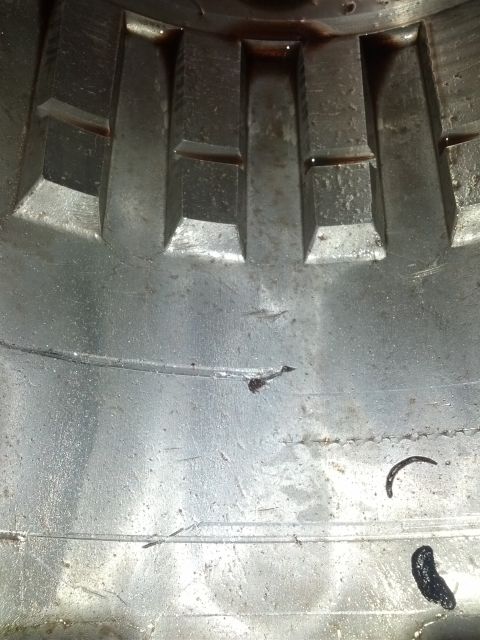 1995 Ford Bronco - Metal transmission component with gear teeth and oil residue visible.