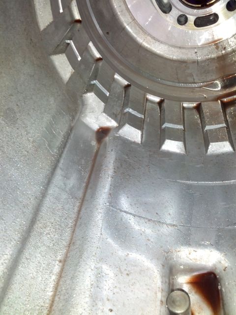 1995 Ford Bronco - Interior view of a transmission housing showing a toothed ring and evidence of fluid leakage.
