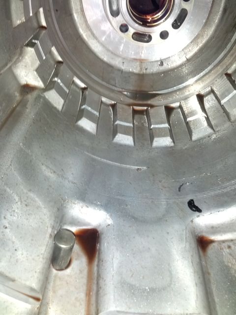 1995 Ford Bronco - Close-up view of the internal components of a transmission housing, showing metal fins and fluid stains.