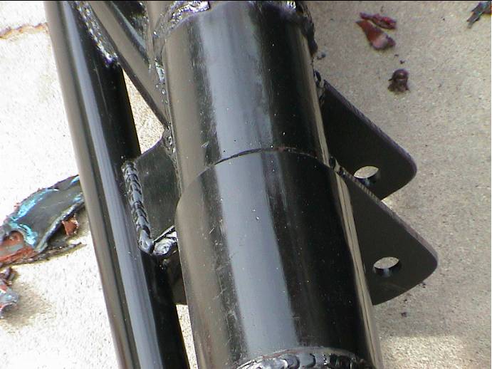 Close-up of welded gloss black suspension link tube and two-hole mounting tab