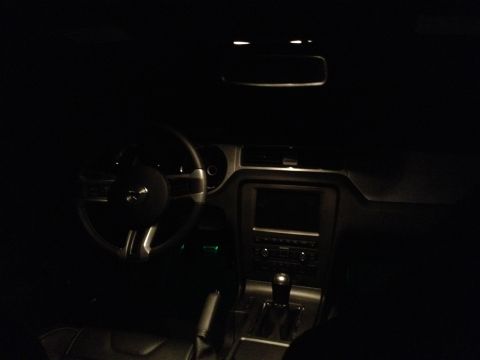 2013 Ford Mustang - Interior view of a 2013 Ford Mustang at night, illuminated by interior lights.