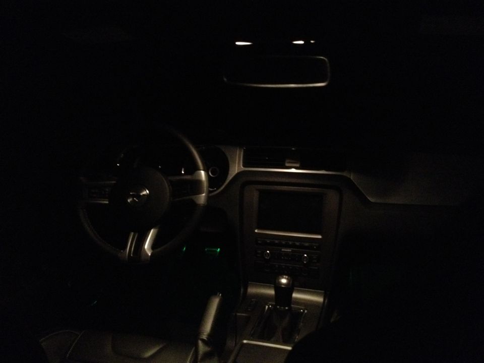 2013 Ford Mustang interior at night, showing steering wheel, dashboard, and center console