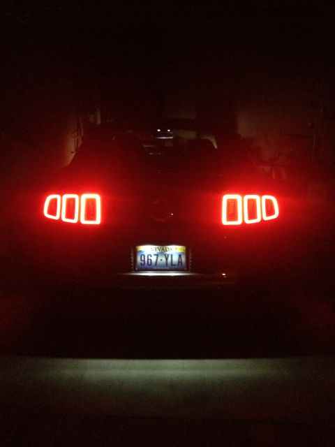 2013 Ford Mustang - The distinctive triple-bar taillights are visible on the rear of the car at night.
