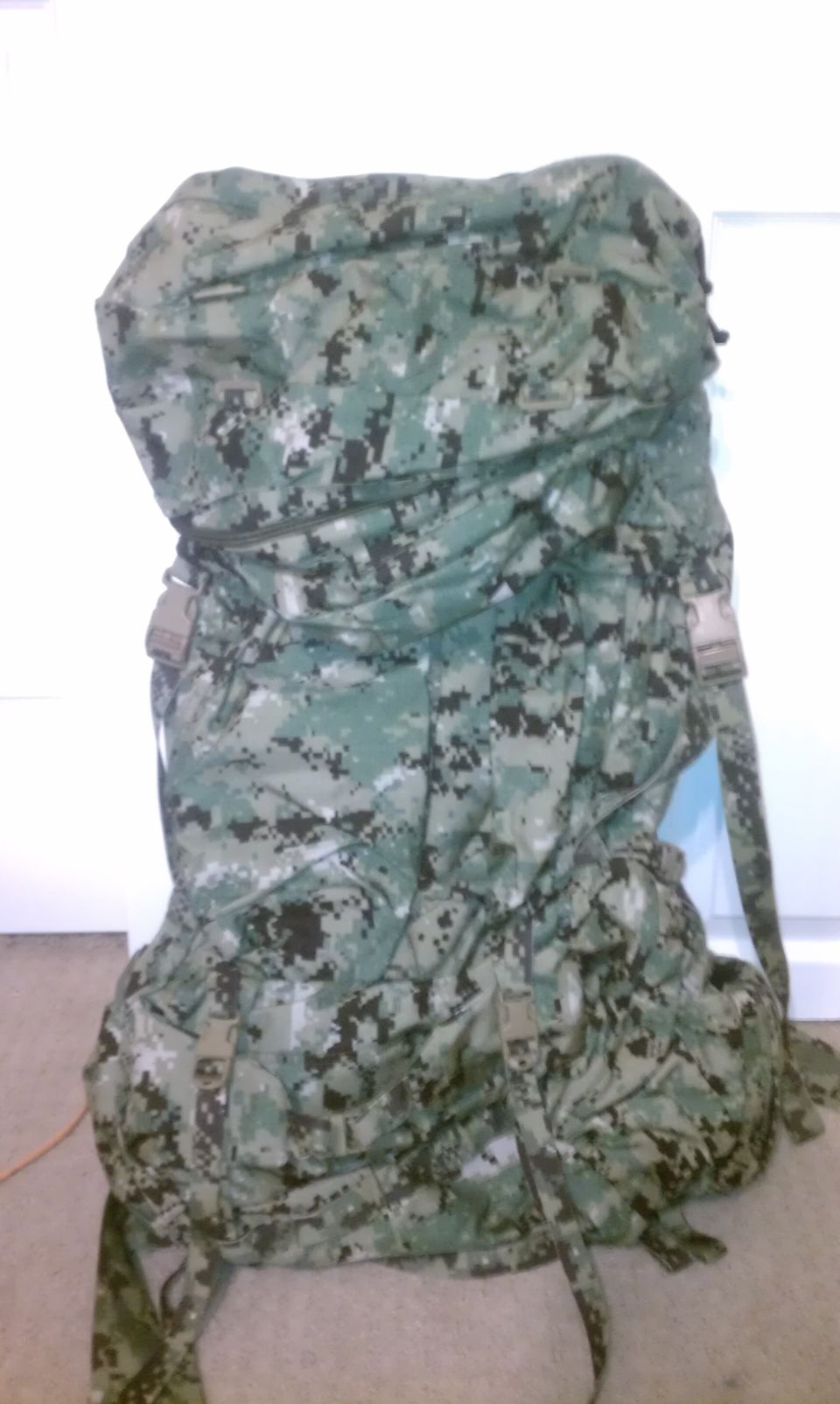 Camouflage backpack with multiple pouches and straps, digital pattern