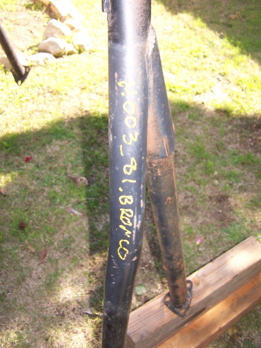 Black metal roll bar section with yellow writing: "003_81.BRONCO"