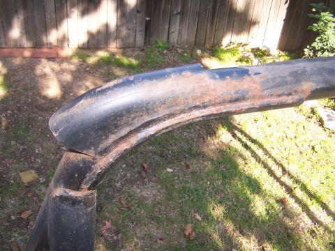 1990 Ford Bronco - A close-up view of a rusty metal bar, possibly a roll bar, lying on the grass.