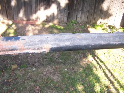1990 Ford Bronco - A rusty black roll bar is shown against a wooden fence and grassy yard.