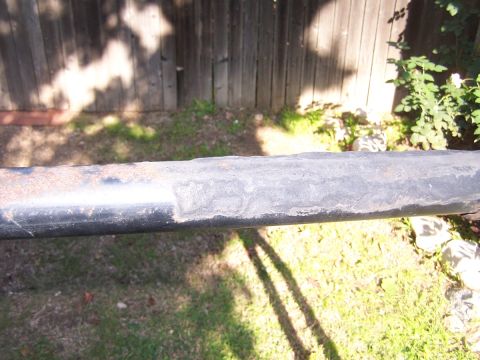 1990 Ford Bronco - This is a close-up of a rusted metal bar, likely a part from a vehicle or structure.