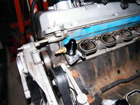 2004 Ford Crown Victoria - Detail of engine components, showing a black fitting and part of the belt drive system.