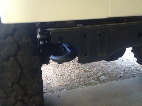 2000 Jeep TJ - Close-up of a tow hook mounted to the frame of a 2000 Jeep TJ, with a tire in view.
