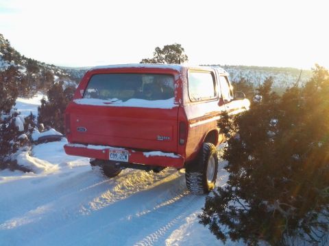 1979 Ford Bronco - 1979 Ford Bronco on a snowy trail with sun glare.