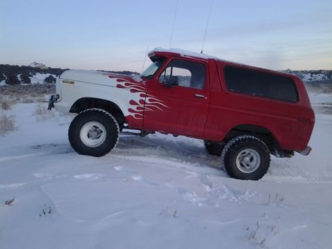 1979 Ford Bronco - A red and white 1978 Ford Bronco with flame decals navigates a snowy landscape.