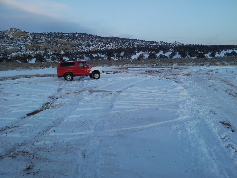 Red and white 1979 Ford Bronco parked in snow