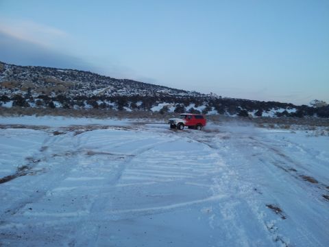 1979 Ford Bronco - SUV driving in a snowy landscape during the day.