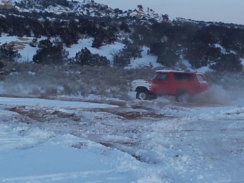 1979 Ford Bronco - SUV driving through snow and mud, possibly a 1978 Ford Bronco.