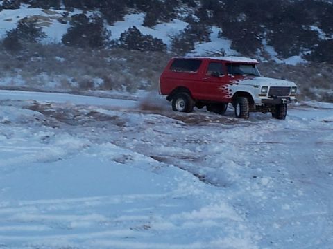 1979 Ford Bronco - A red and white 1978 Ford Bronco with flame decals navigates a snowy terrain.