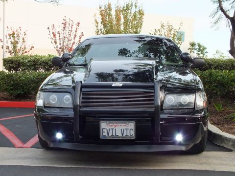 2003 Ford Crown Victoria - Close front view of a black Crown Victoria sedan with billet grille, brush guard and angel-eye headlights.