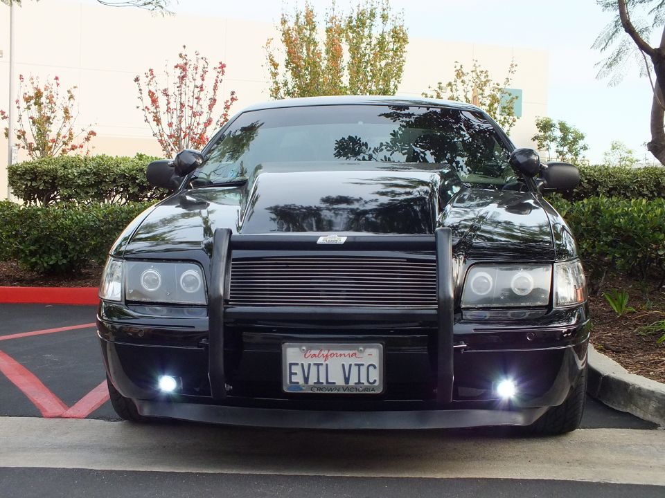 Front of black Crown Victoria with halo projector headlights and EVIL VIC plate