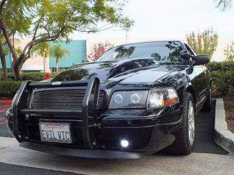 2003 Ford Crown Victoria - Front quarter of a blacked-out Crown Victoria showing chrome wheels, billet grille and EVIL VIC plate.