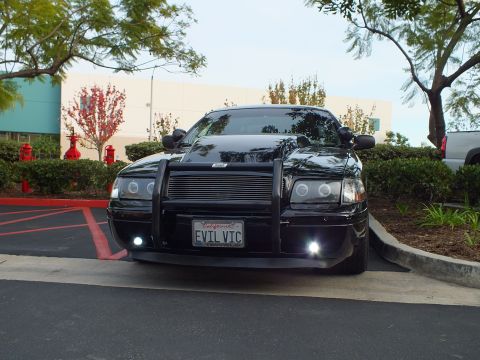 2003 Ford Crown Victoria - Front of a blacked-out Crown Victoria sedan with billet grille, halo headlights and EVIL VIC plate.