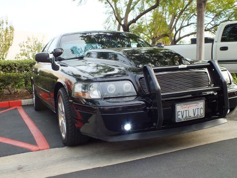 2003 Ford Crown Victoria - Front quarter of a blacked-out Crown Victoria showing chrome wheels, billet grille and amber markers.