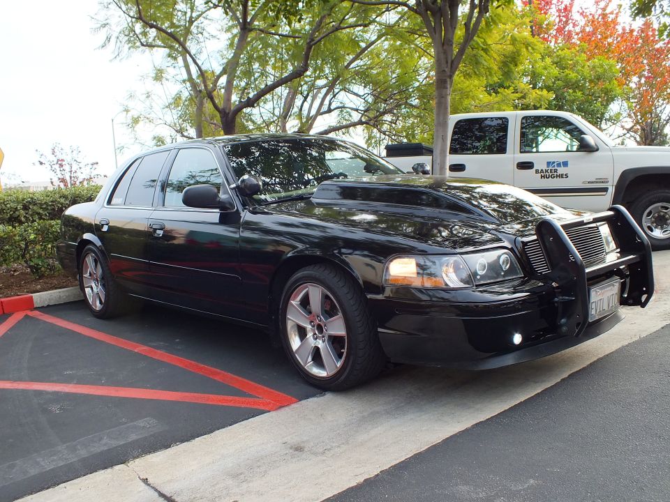 Black Crown Victoria sedan side profile with chrome wheels and front brush guard