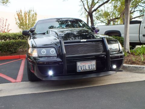 2003 Ford Crown Victoria - Front of a slammed blacked-out Crown Victoria sedan with billet grille, push bar and lit fog lamps.