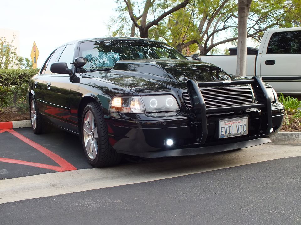 Black Crown Victoria front three-quarter showing halo lights, billet grille and EVIL VIC plate