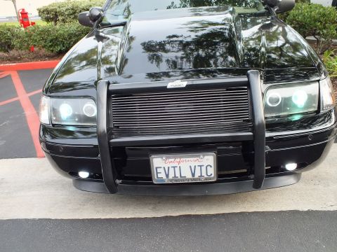 2003 Ford Crown Victoria - Close front shot of a Crown Victoria, billet grille and grille guard, halo headlights and foglights on.