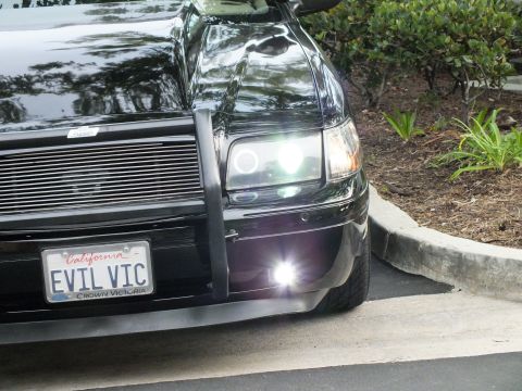 2003 Ford Crown Victoria - Detail of a Crown Victoria nose with halo projector lamp, billet grille and twin white foglights lit.