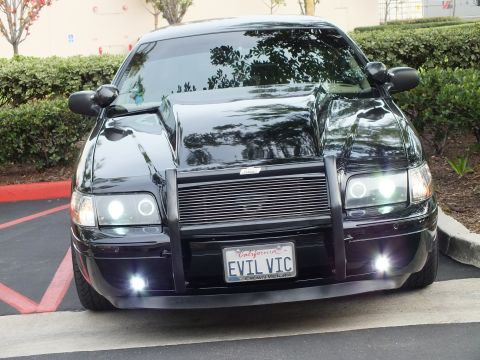 2003 Ford Crown Victoria - Front view of a low black Crown Victoria, grille guard framing billet grille, halo lamps and foglights on.