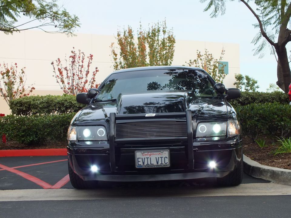 Black Ford Crown Victoria parked head-on, push bar, billet grille, halo lamps, EVIL VIC plate
