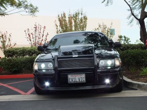 2003 Ford Crown Victoria - Front of a black Crown Victoria with grille guard and billet grille, halo headlights and foglights lit.