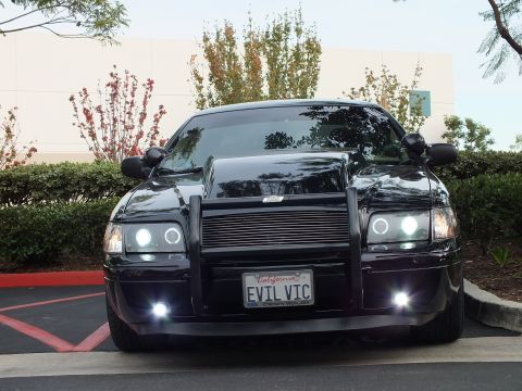 2003 Ford Crown Victoria - Symmetric front view of a lowered Crown Victoria, grille guard and billet grille, foglights illuminated.