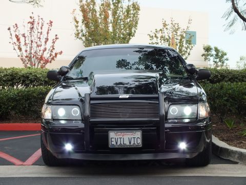 2003 Ford Crown Victoria - Lowered black Crown Victoria, billet grille and halo headlights lit, custom front guard.