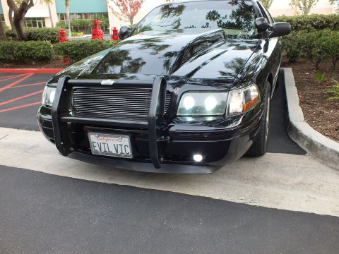 2003 Ford Crown Victoria - Lowered black sedan angled close view, custom front guard, billet grille and halo headlight.