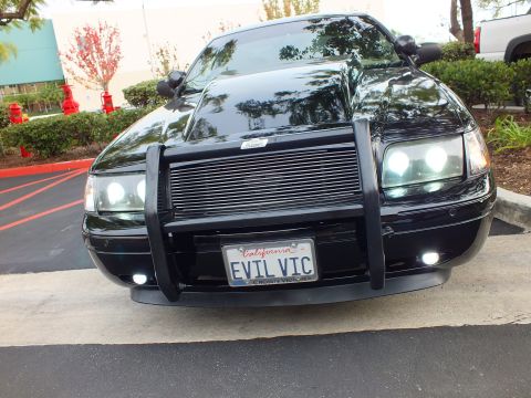 2003 Ford Crown Victoria - Front view of a black Crown Victoria fitted with a chrome billet grille and brush guard, plate reads EVIL VIC.